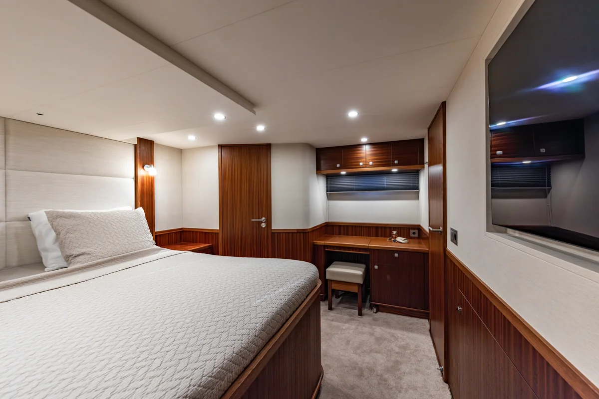 Elling E6 double cabin with white bedding, a desk, overhead cabinets and wood-paneled walls.